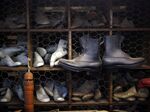 A pair of boots hang in front of wooden shoe patterns at a factory in Omaha, Nebraska.