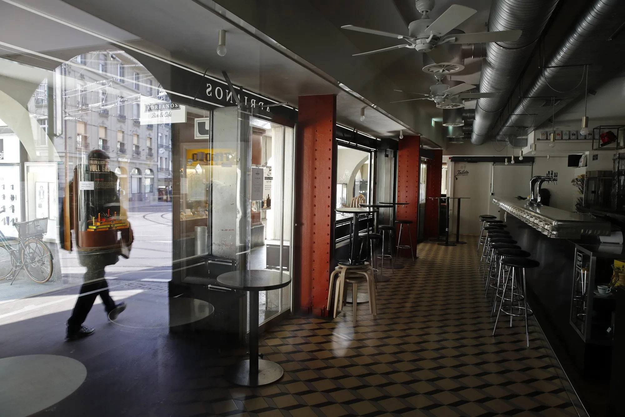 A pedestrian walks past a closed cafe in Bern&nbsp;on March 27.