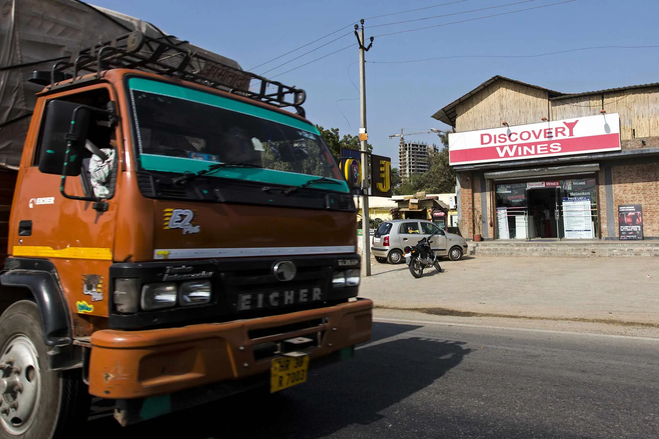 A truck drives past a roadside liquor store located along a highway in Gurgaon, Haryana, India, on Feb. 20.
