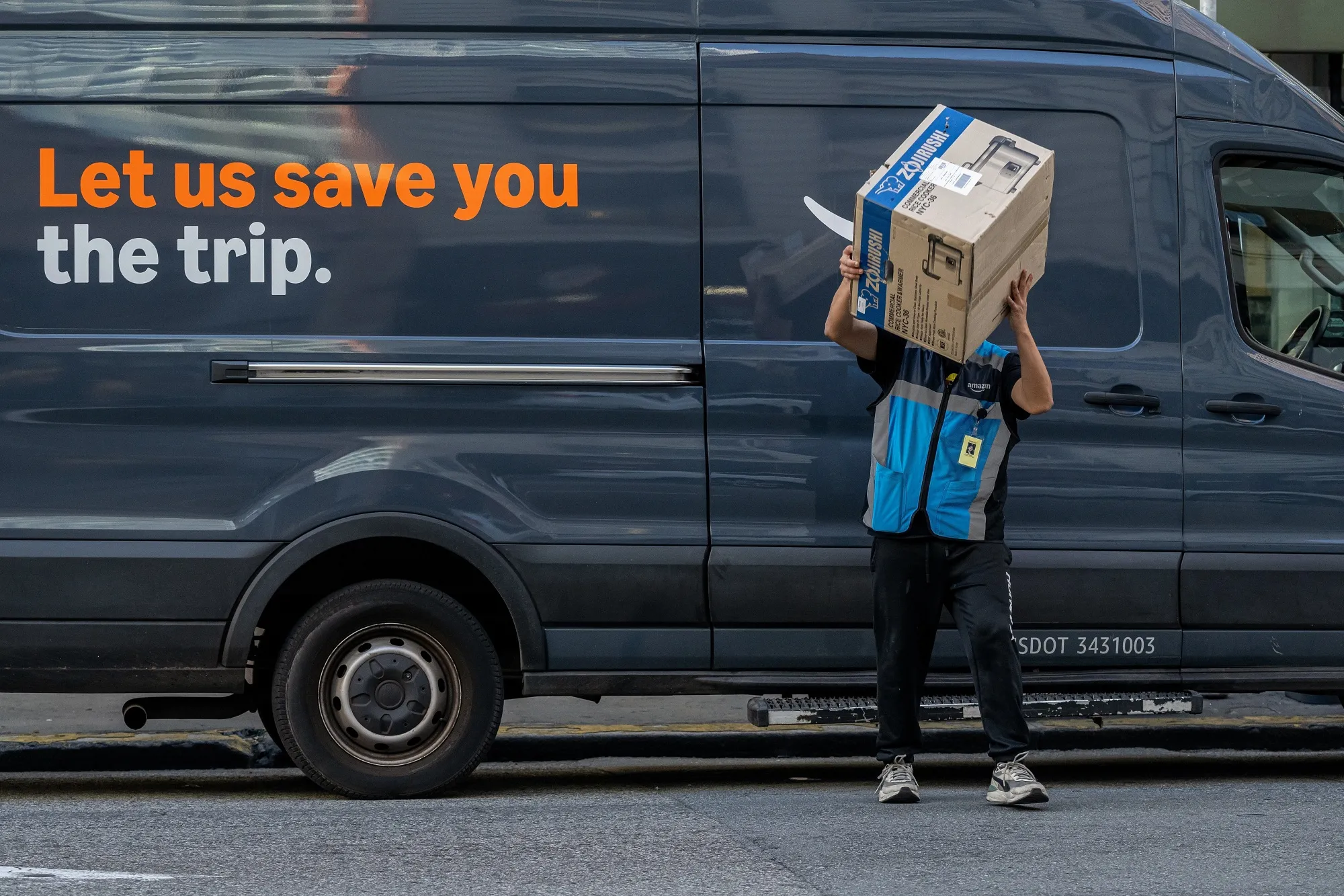 An Amazon worker deliverying a parcel in San Francisco, California, US.
