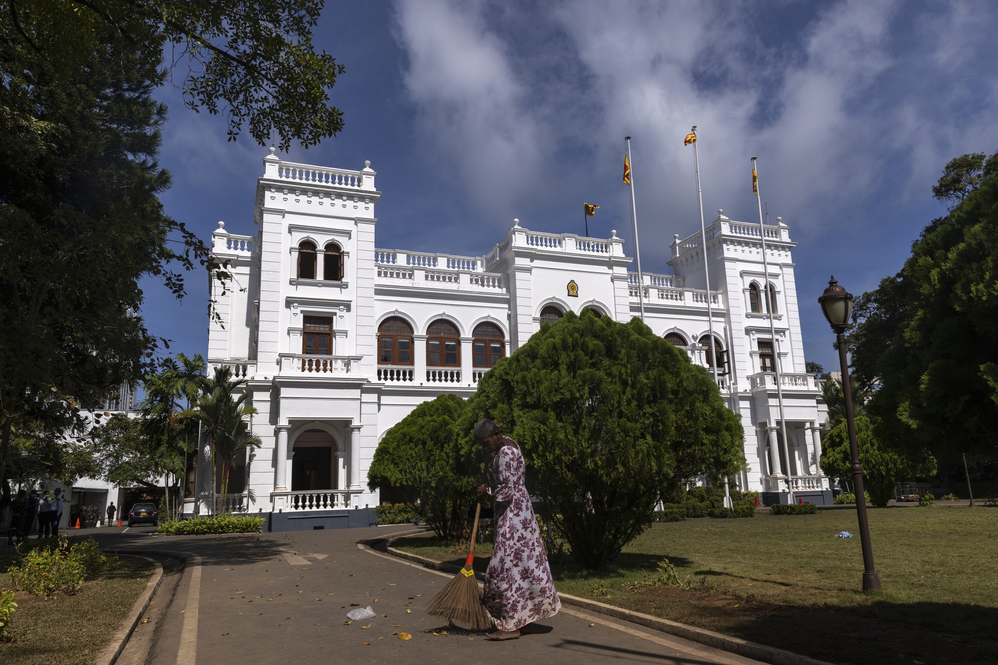 A woman sweeps a road in front the prime minister's office in Colombo.