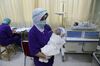 A nurse holds a newborn baby wearing face shield to protect against Covid-19 in Jakarta, in April 2020.