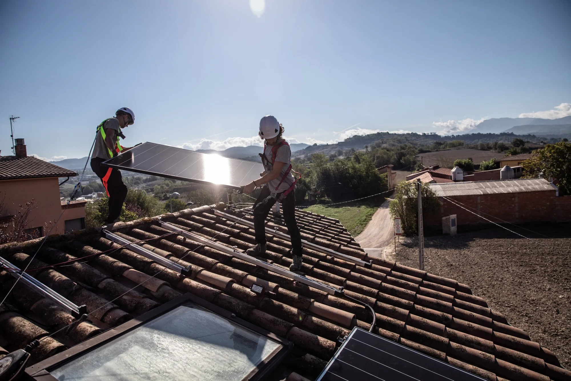 Engineers from Sud Energies Renovables SL install solar panels onto the roof of a residential property in Barcelona, Spain.