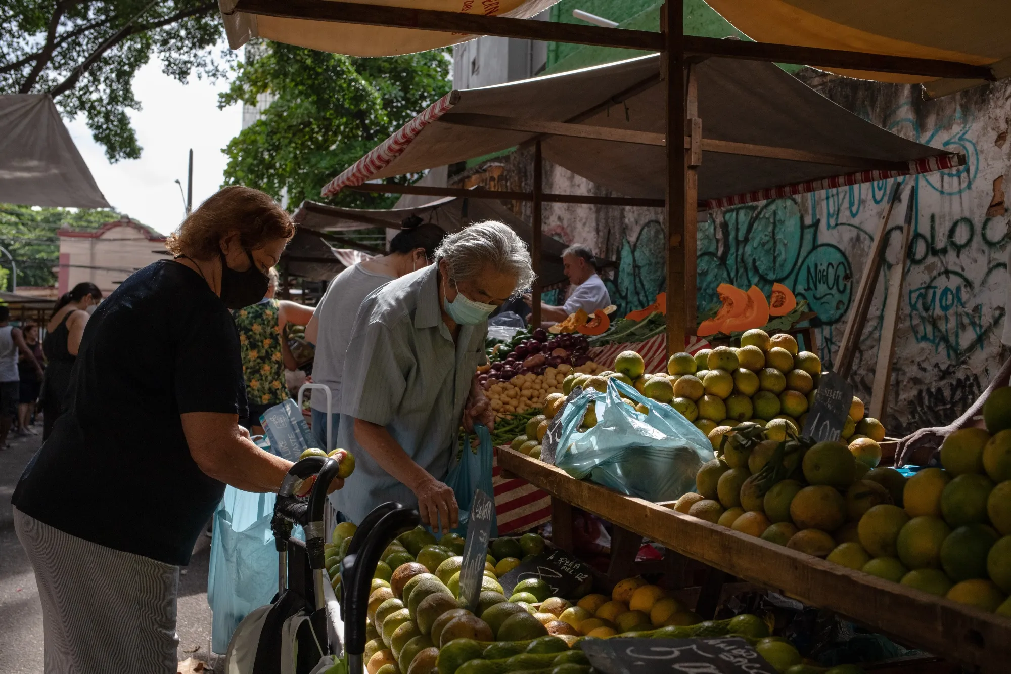 Shoppers browse produce at an outdoor market in the Tijuca neighborhood of Rio de Janeiro, Brazil.