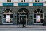 A cyclist passes a Jyske Bank A/S bank branch in Copenhagen.