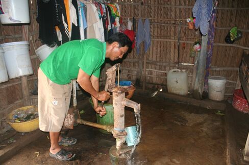 Nguyen Van Nhin pumps well water inside his home.