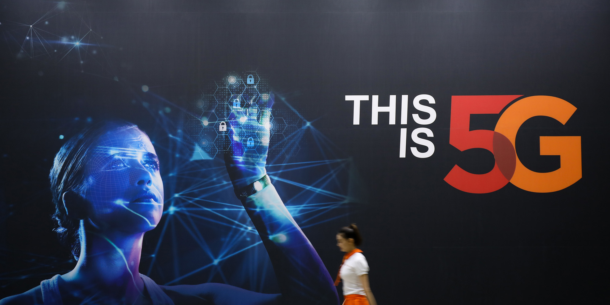 A woman walks past an advertisement for SK Telecom Co. at the World IT Show 2018 in Seoul.