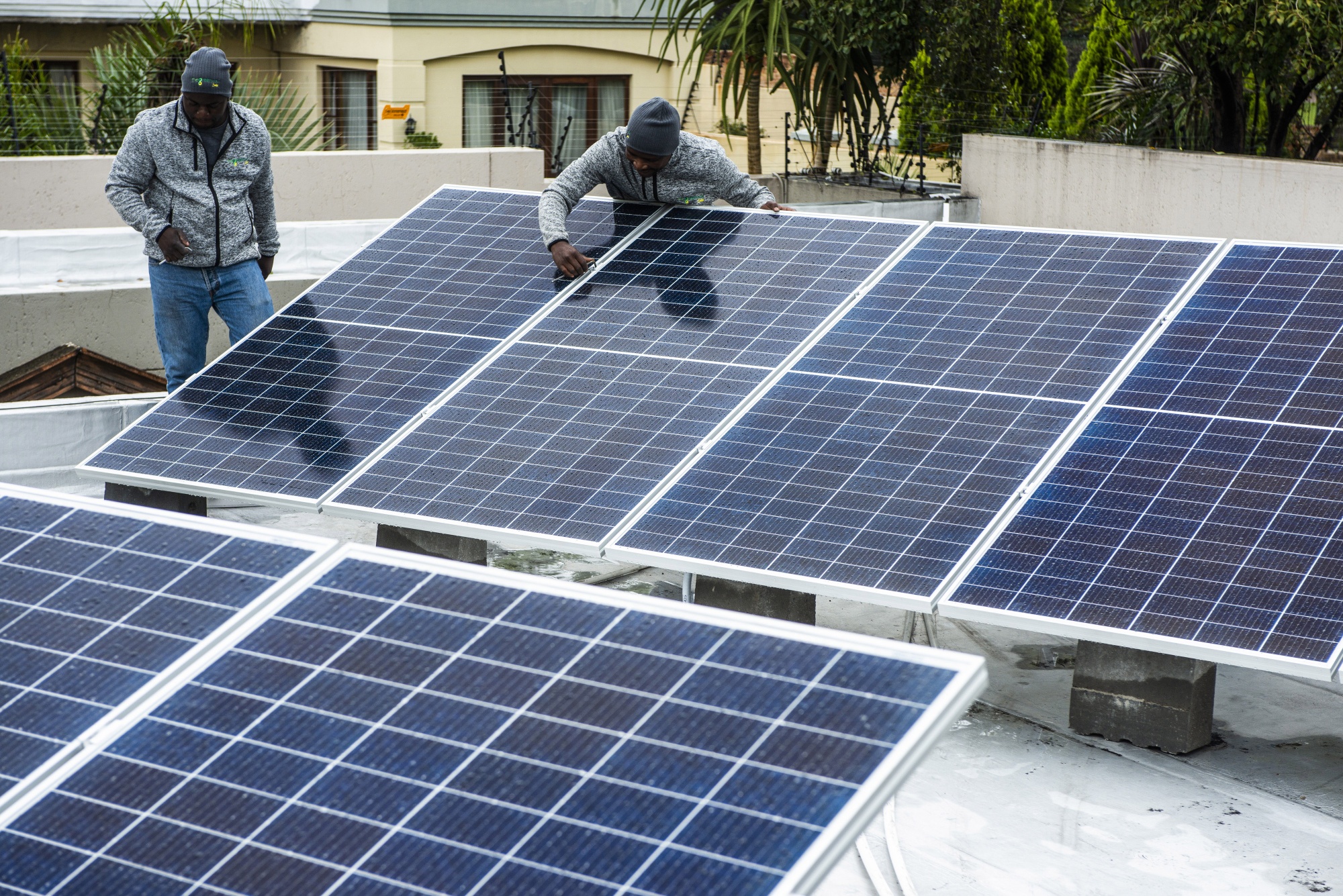 Workers install solar panels onto the roof of a residential property in Johannesburg.