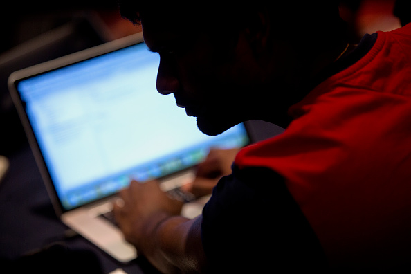The silhouette of an attendee is seen while he works on an Apple Inc. laptop computer while participating in the Yahoo! Inc. Mobile Developer Conference Hackathon in New York, U.S., on Tuesday, Aug. 25, 2015. The Hackathon is an opportunity for mobile developers to come together and hack around the Yahoo! Inc. Mobile Developer Suite.