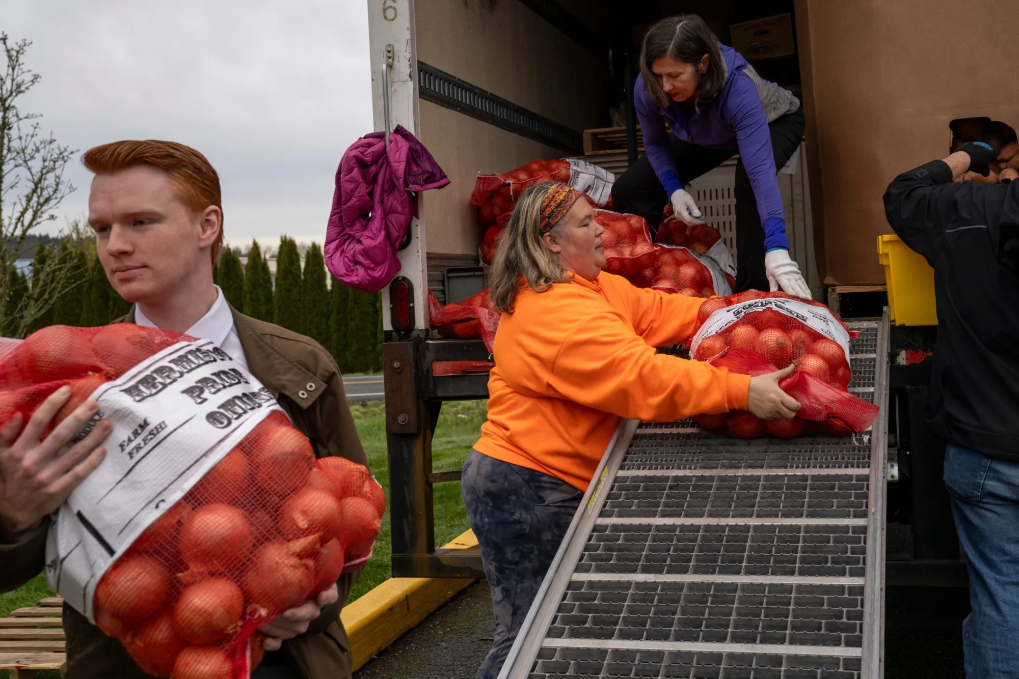 
Volunteers unload food for a drive-thru fresh food distribution event in Redmond.
