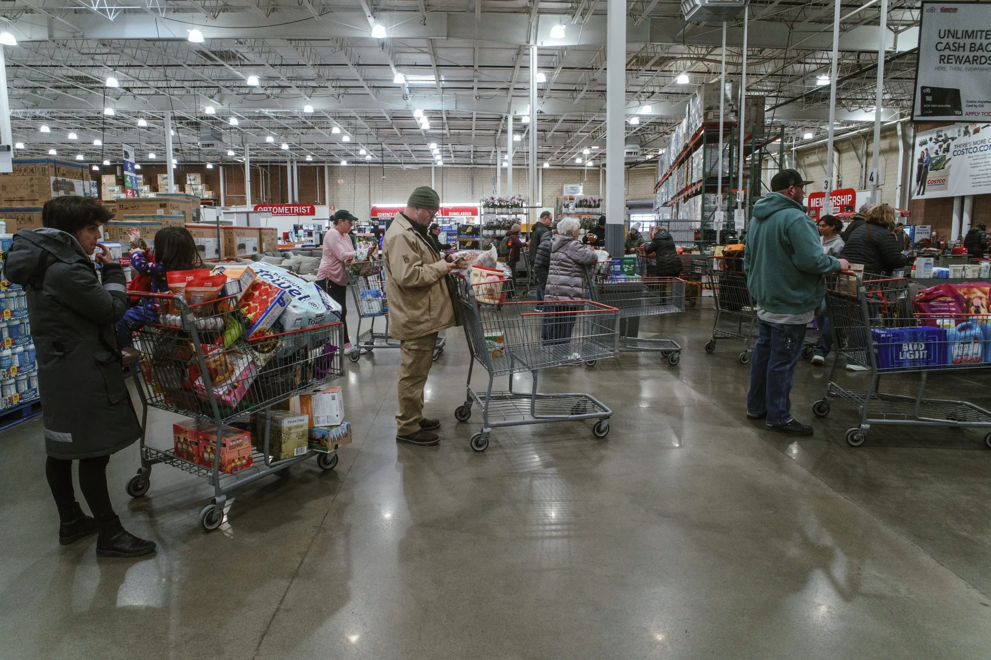 Shoppers wait in line at the cash registers at a grocery store in Lenexa, Kansas.