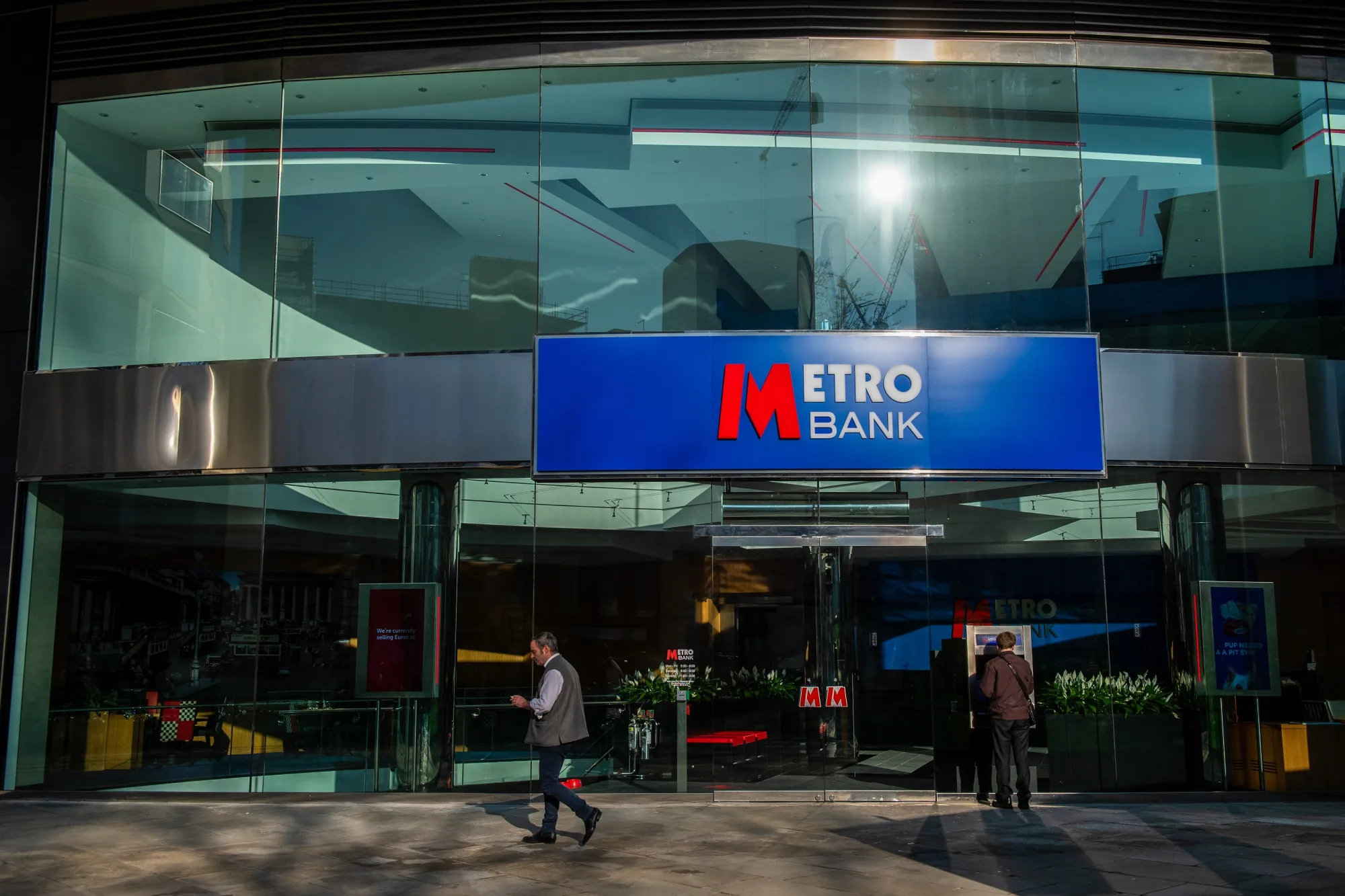 A pedestrian passes a branch of Metro Bank Plc in the City of London.