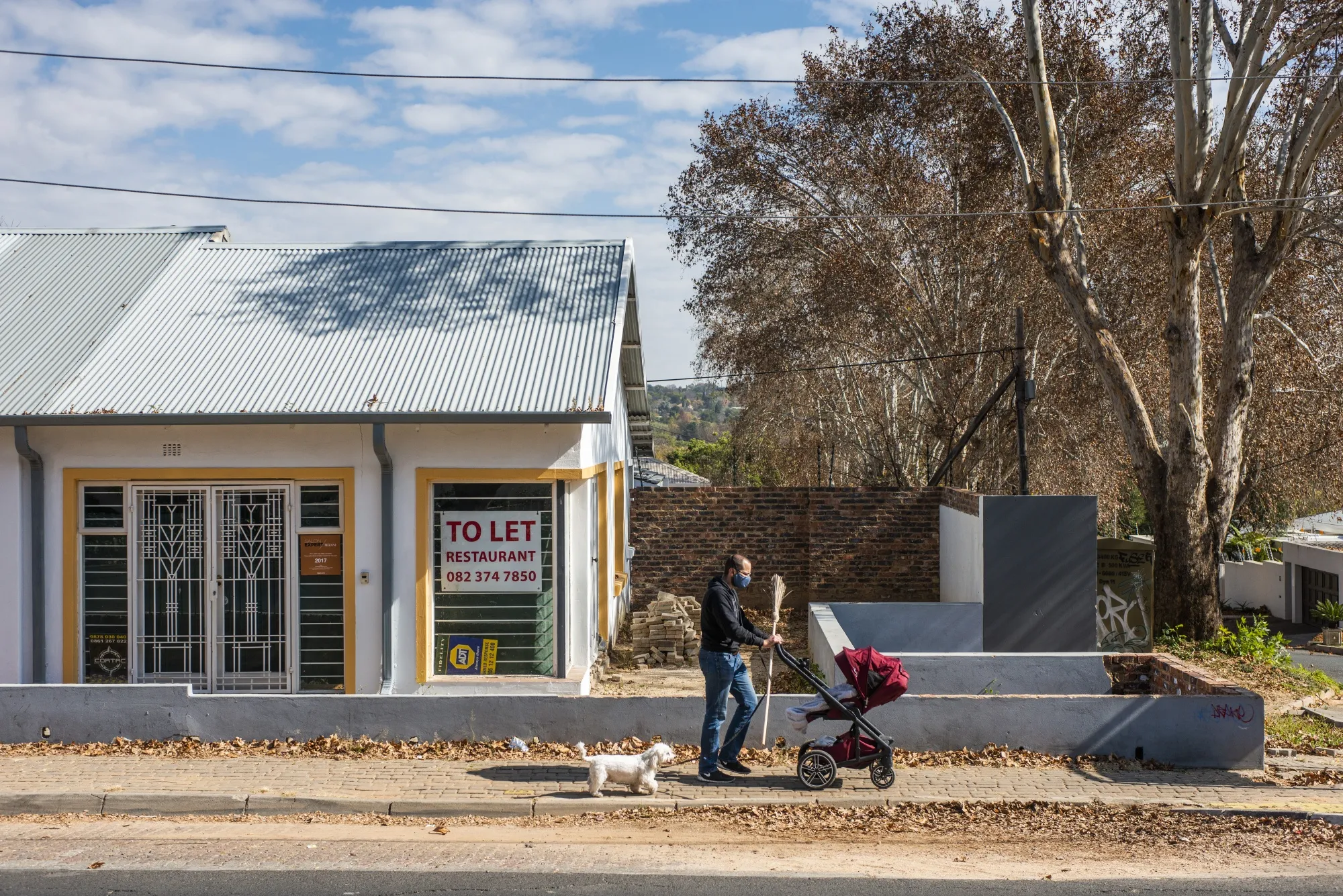 A pedestrian wearing a protective face mask walks by a restaurant unit standing empty and available to let in&nbsp;Johannesburg.