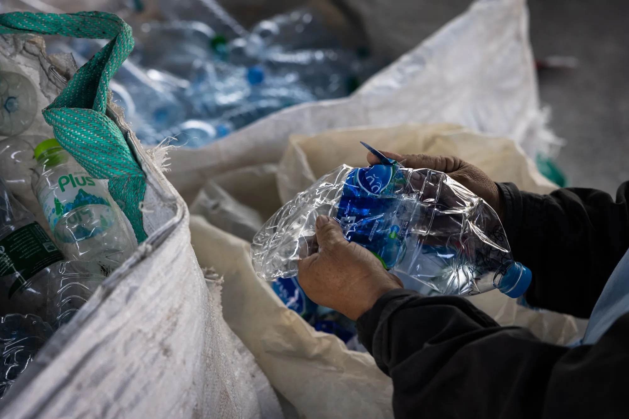 A volunteer removes the labels from plastic bottles for processing at a recycling center in Rayong, Thailand, on Wednesday, Dec. 14, 2022. Global plastic waste has more than doubled over the past two decades to 353 million metric tons annually, a number that the Organisation for Economic Co-operation and Development expects to almost triple by 2060.
