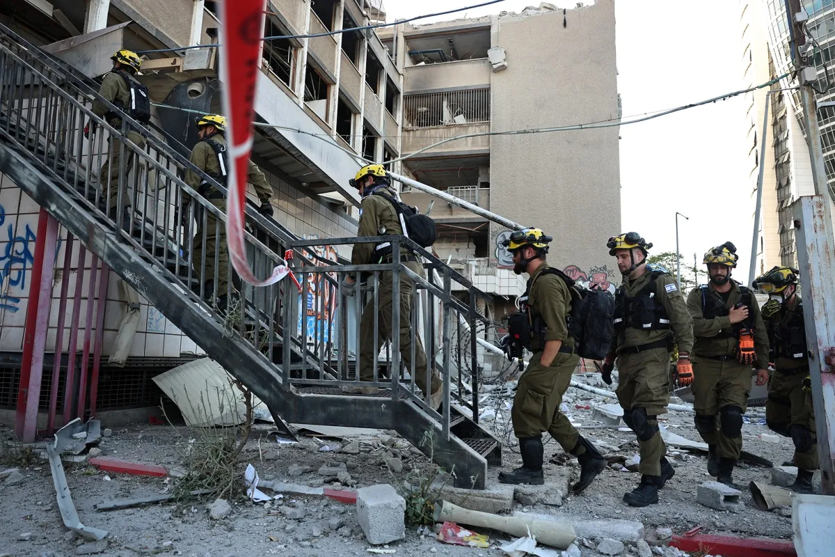 Israeli first responders enter a building that was hit by an Iranian strike in Haifa on June 20.