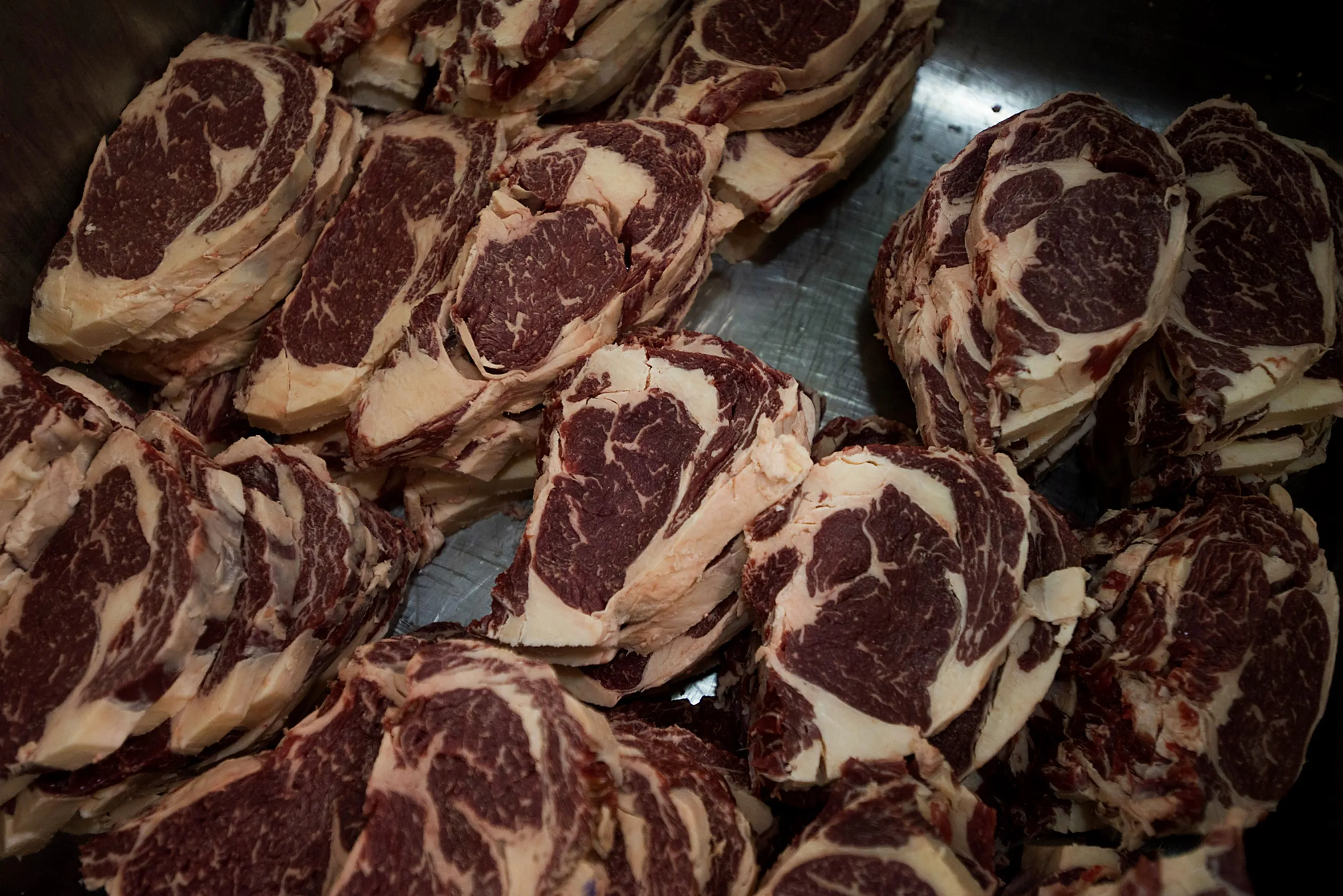 Rib-eye cuts of beef sit stacked for packaging in Ohio.
