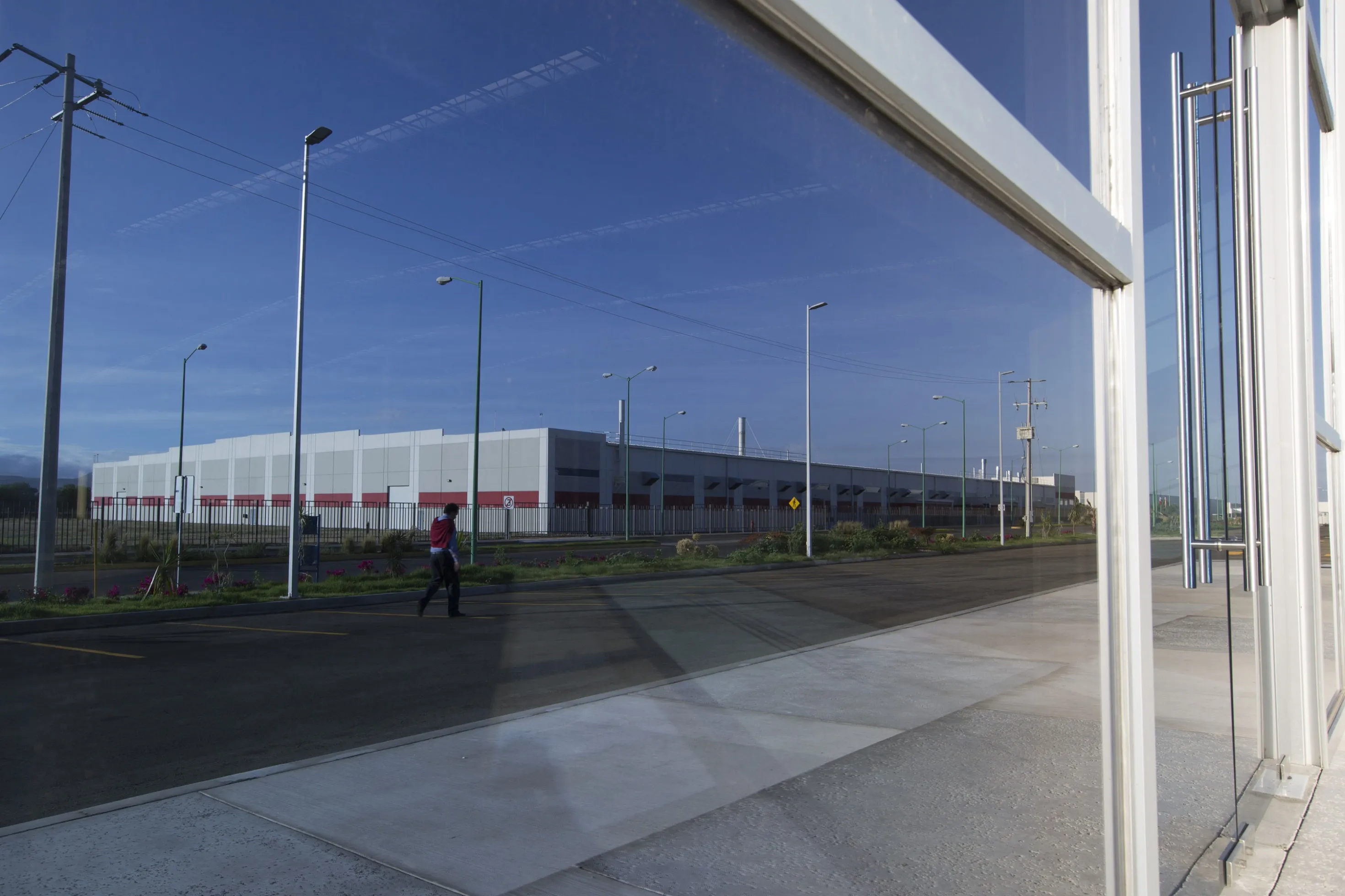 A man walks near the Meggitt Plc warehouse in Corp. Inmobiliaria Vesta SAB's Aerospace Park in Queretero, Mexico, on Monday, June 24, 2013.