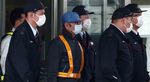 TOPSHOT - Former Nissan chairman Carlos Ghosn (C-light blue cap) is escorted as he walks out of the Tokyo Detention House following his release on bail in Tokyo on March 6, 2019. - Ghosn posted bail of 1 billion yen (9 million USD) in cash on March 6, paving the way for his release from the Tokyo detention centre after more than three months in custody. (Photo by Behrouz MEHRI / AFP) (Photo by BEHROUZ MEHRI/AFP via Getty Images)