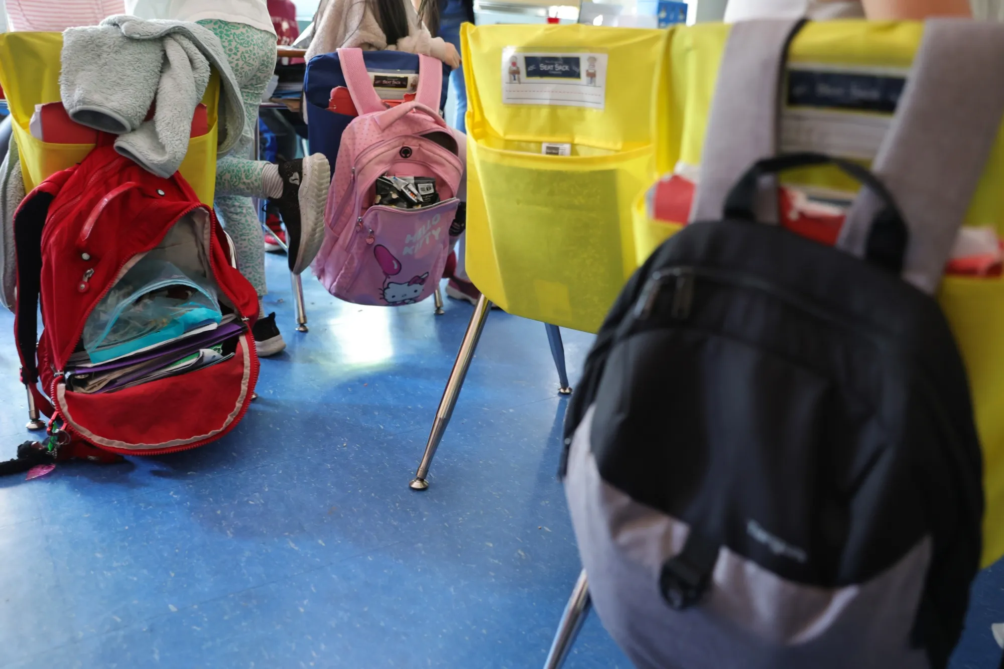 Student backpacks hang on the backs of classroom chairs at a New York City public school.