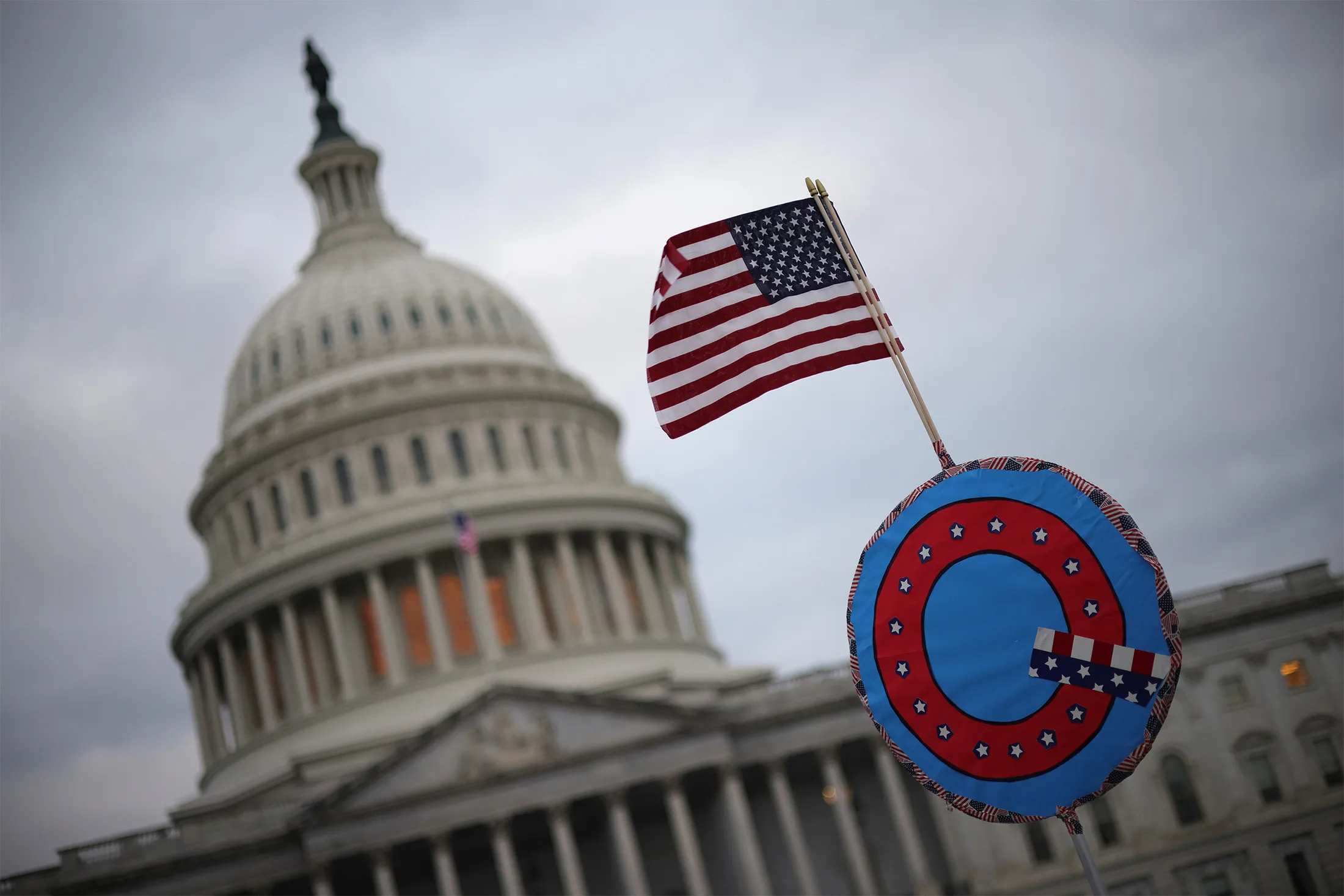 Supporters of U.S. President Donald Trump fly a U.S. flag with a symbol from the group QAnon as they gather outside the U.S. Capitol Jan.&nbsp;6.