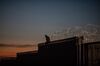 A man sits on top of a section of a U.S.-Mexico border wall at dusk in Tijuana, Mexico, on Sunday, Nov. 18, 2018. President�Donald Trump�said Saturday it is a good time to shut down the government to gain leverage with Democrats to fund his demands for a wall along the U.S. border with Mexico.