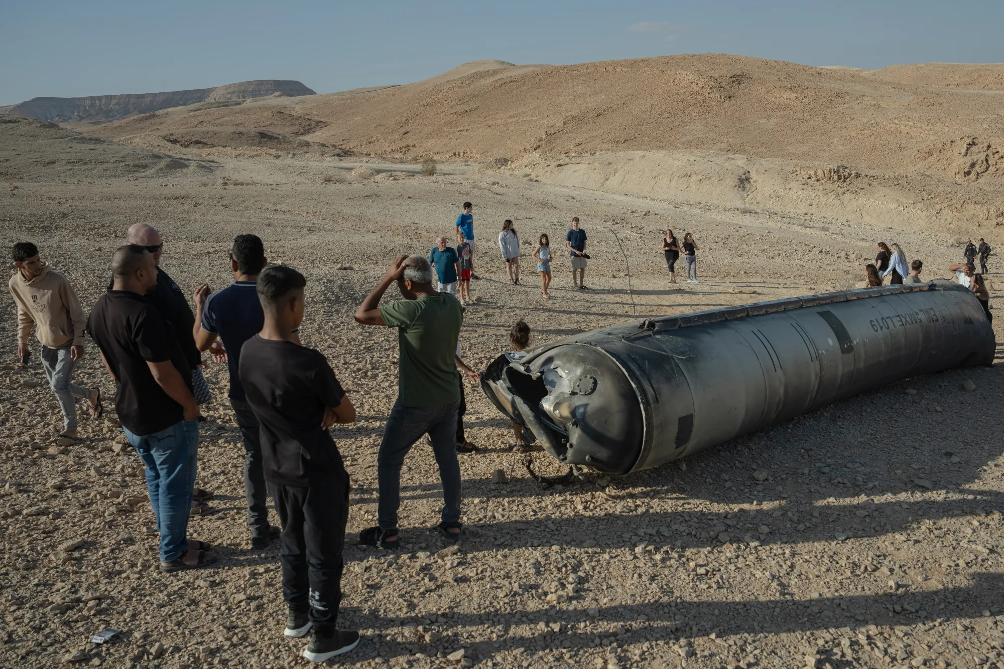 People stand near the remains of a missile following an attack by Iran near the Dead Sea, Israel, on&nbsp;Oct. 2.