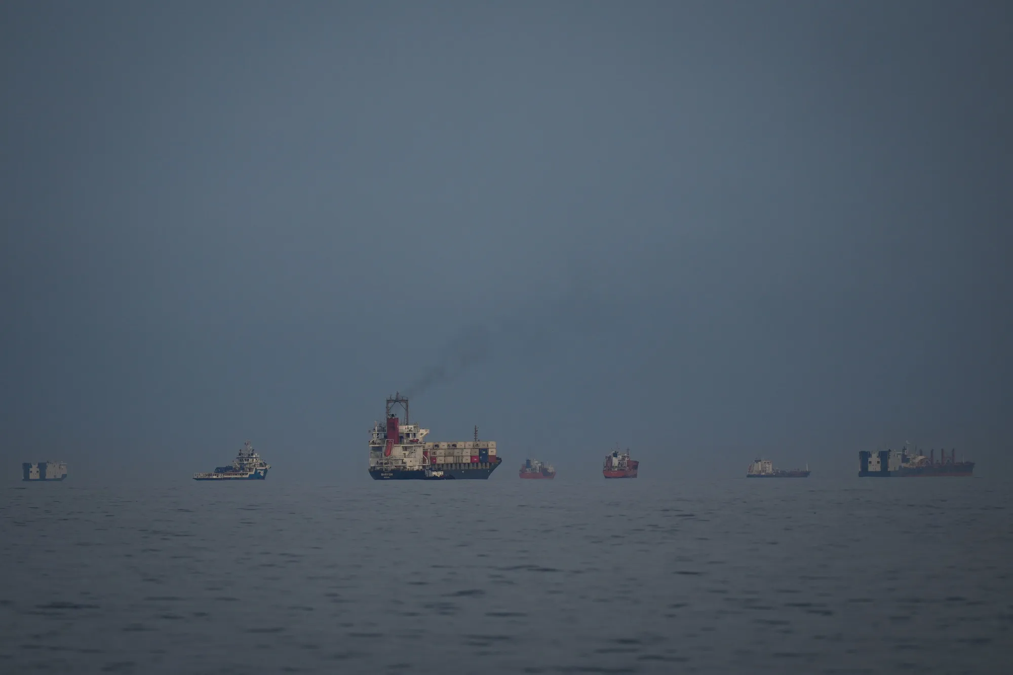 Oil tankers and cargo ships line up in the Strait of Hormuz as seen from Khor Fakkan, United Arab Emirates on March 11.