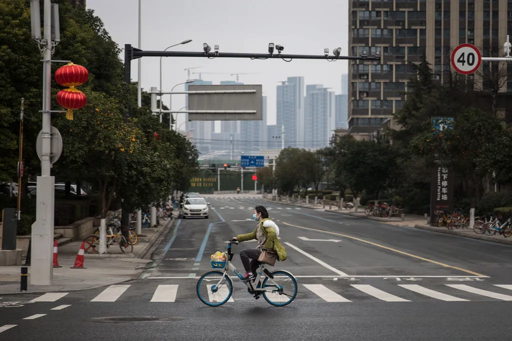 A woman cycles through the deserted streets of Wuhan,&nbsp;Hubei province, China.