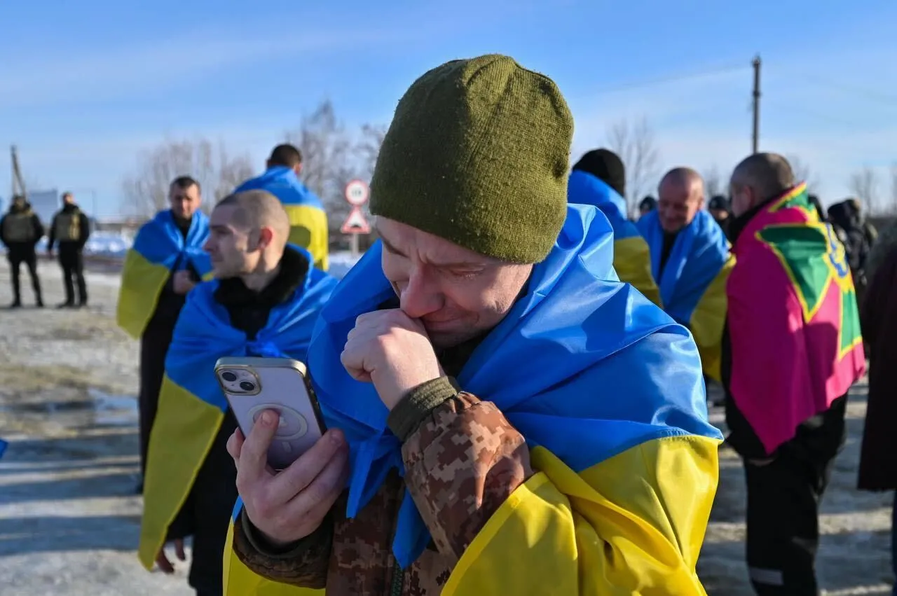 A Ukrainian freed in a prisoner swap with Russia makes a phone call at an undisclosed location in Ukraine on Jan. 31.