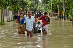 People wade through flood waters in India's Assam state on June 19.