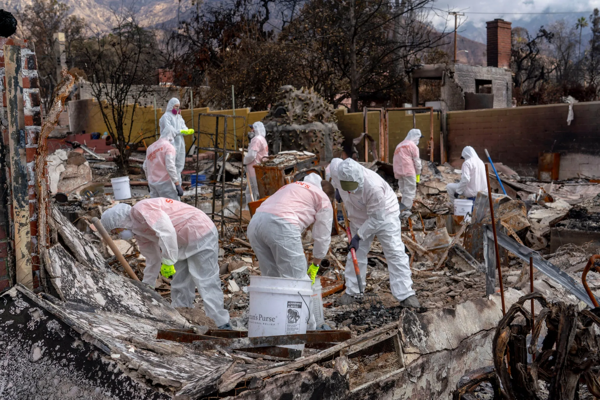 Private contractors remove debris from a home destroyed by the Eaton Fire in Altadena, California.