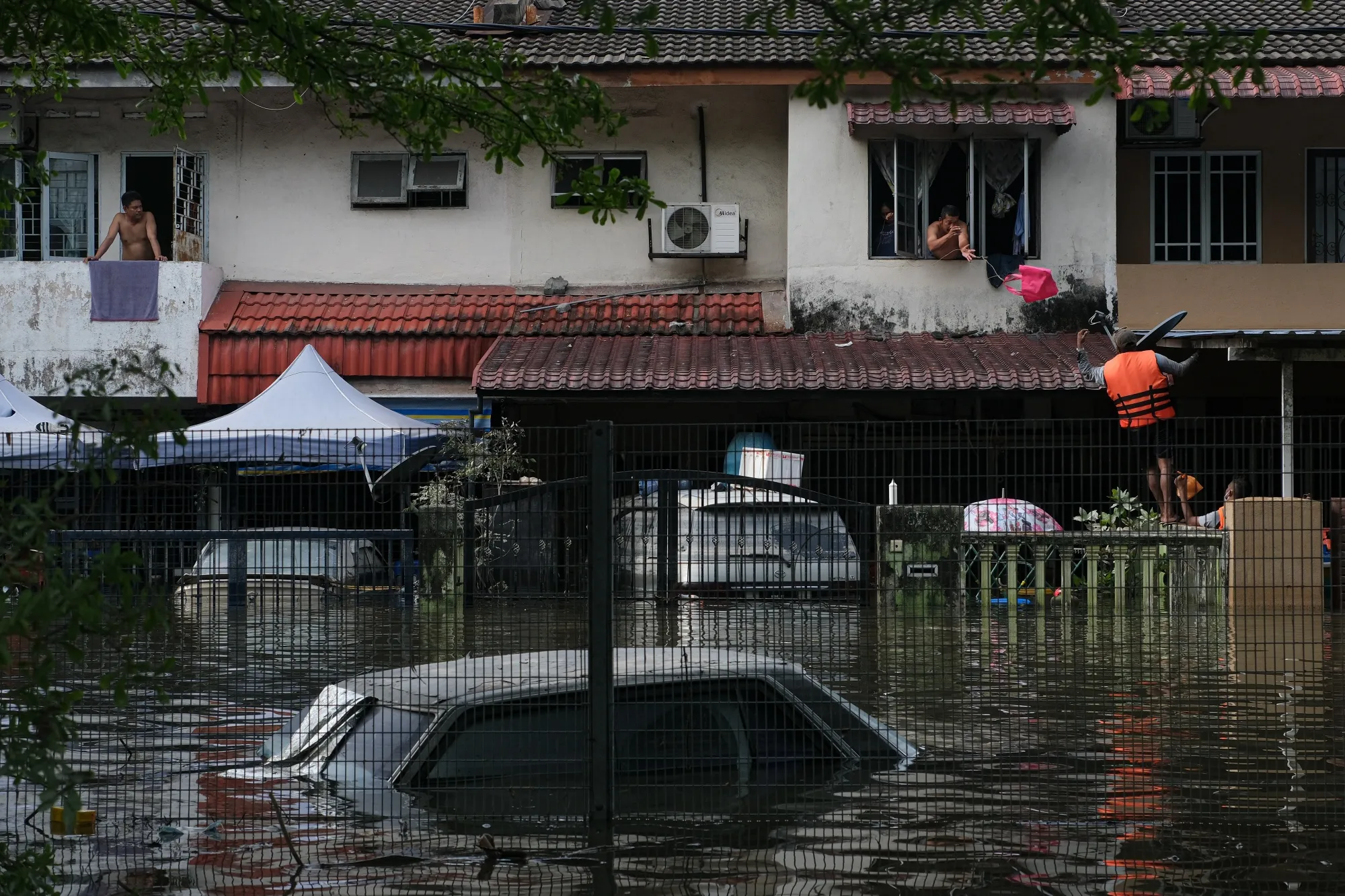 Volunteers deliver food to residents marooned by floodwaters in the Taman Sri Muda township of Shah Alam, Selangor, Malaysia, on Dec. 20.