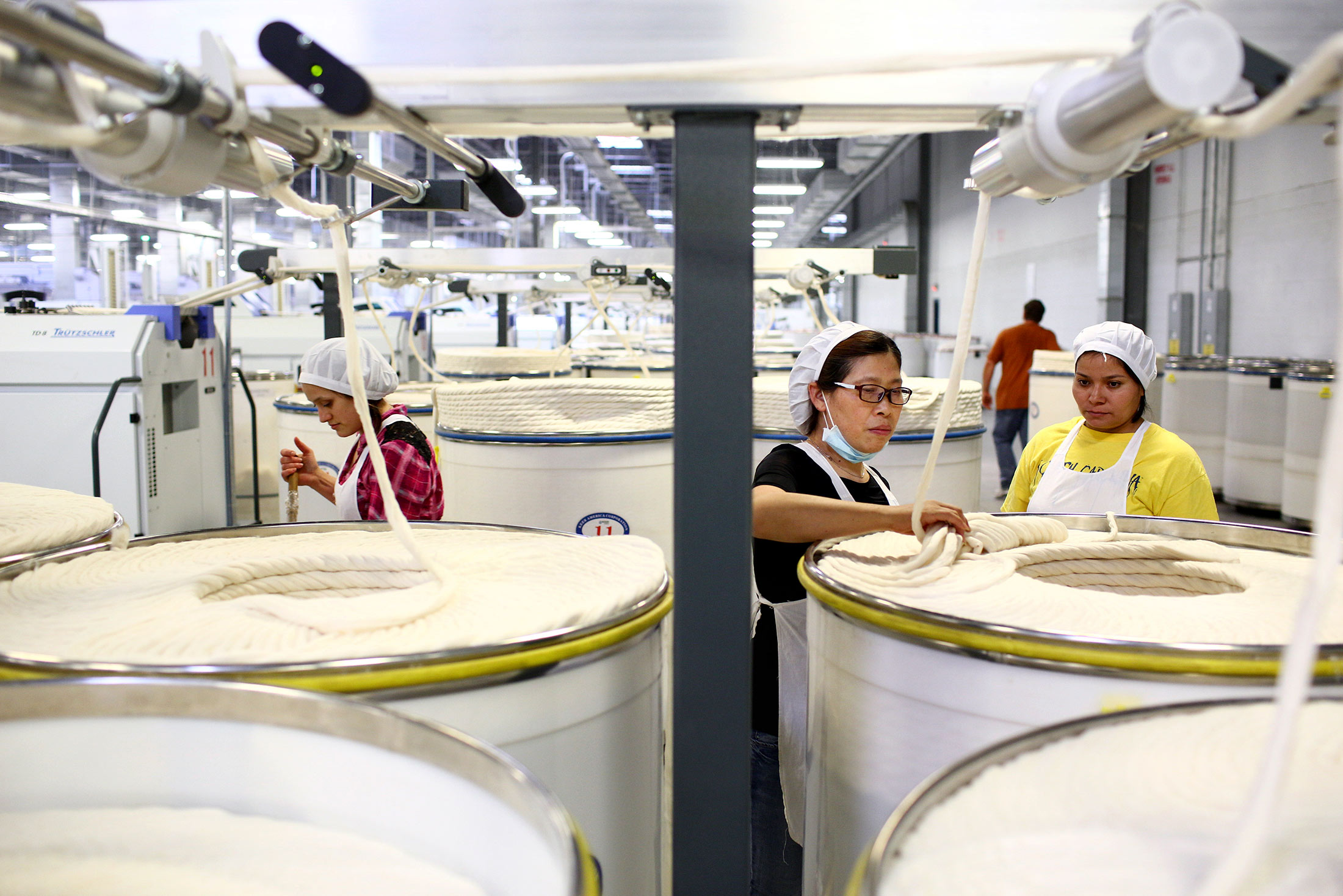 Ni Meijuan, center, with trainees Enabel Perez, right, and Maria Elisena de Leon, left, at Keer Group’s cotton mill in Lancaster County, South Carolina, on May 20, 2015.
