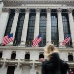 American flags fly as a pedestrian walks past the New York Stock Exchange (NYSE) in New York, U.S., on Friday, Feb. 23, 2018. U.S. stocks rose with Treasuries and the dollar slipped as investors await clues on Federal Reserve policy intentions under new Chairman Jerome Powell.