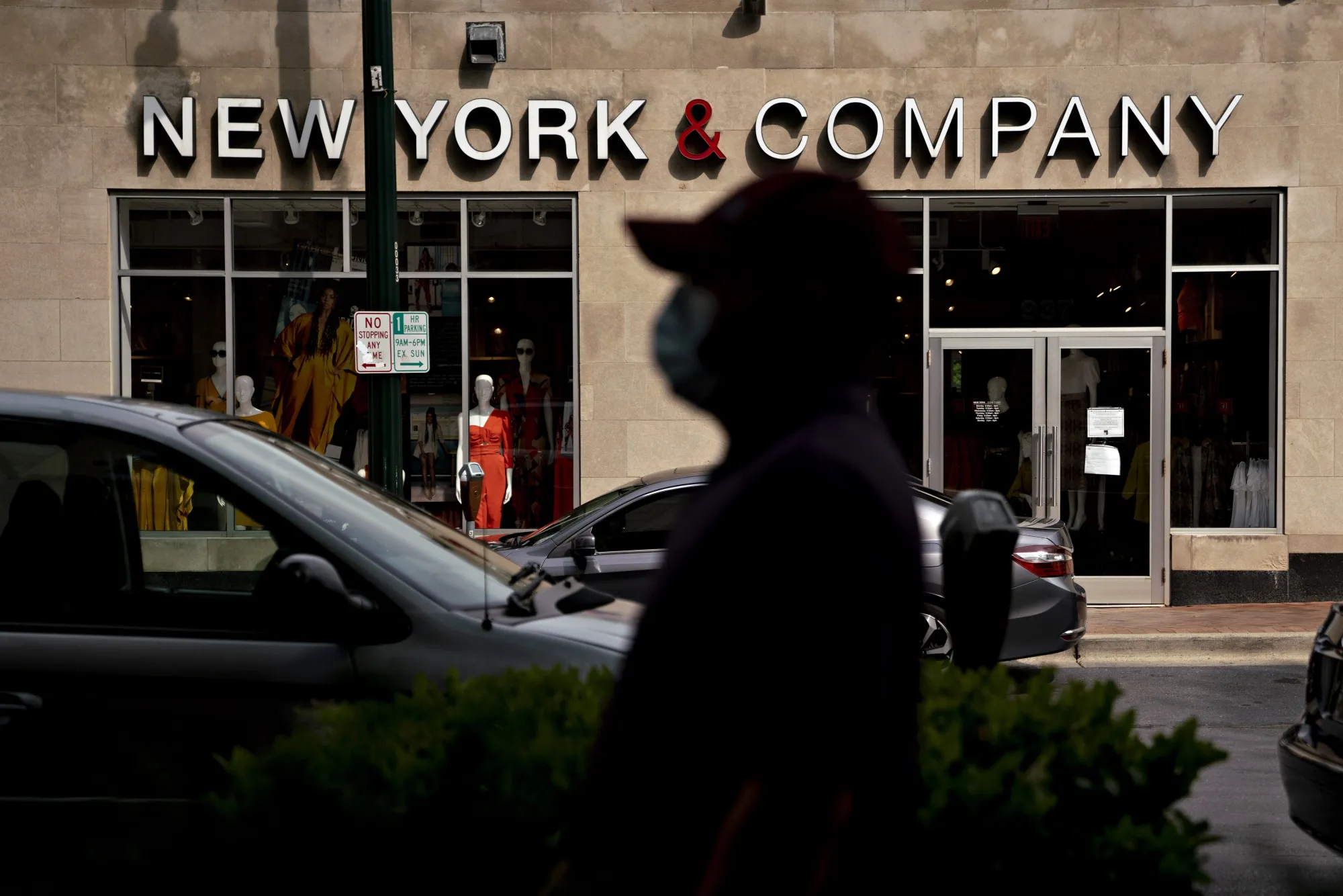 A pedestrian wearing a protective mask walks near a temporarily closed New York &amp; Co. store in Silver Spring, Maryland&nbsp;on June 5.&nbsp;
