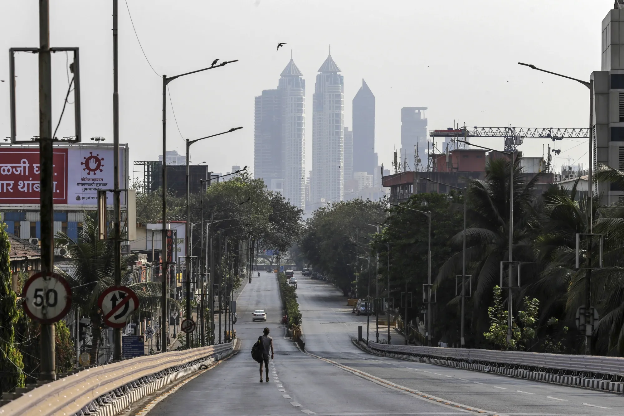 A pedestrian walks along a near-empty road during a lockdown imposed due to the coronavirus in Mumbai on March 25.