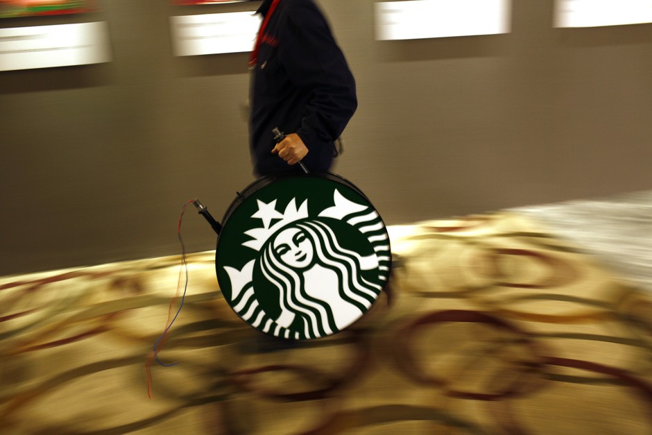 A man carries a Starbucks logo sign after a corporate event.