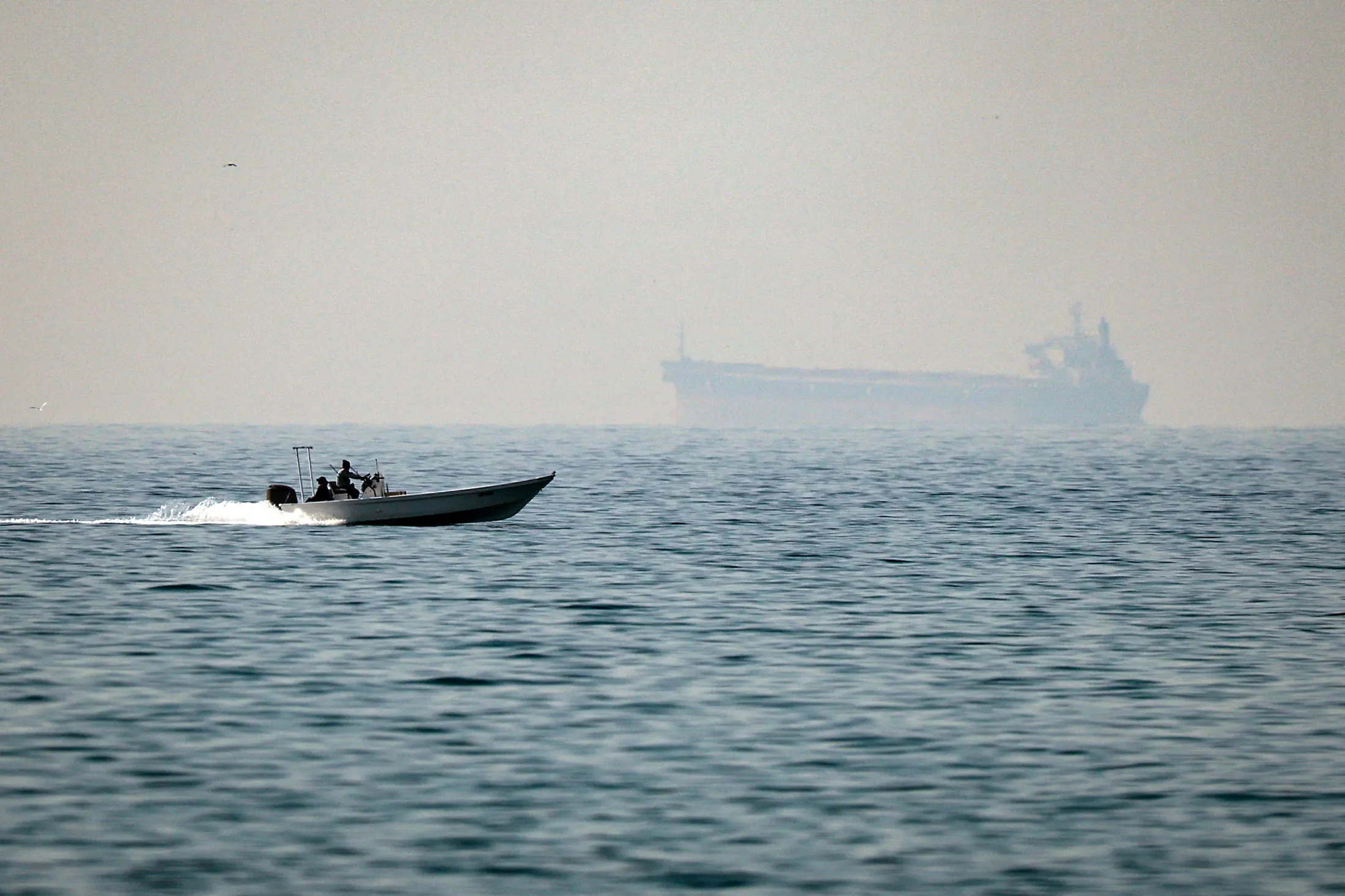 A motorboat passes a tanker in the Strait of Hormuz in February