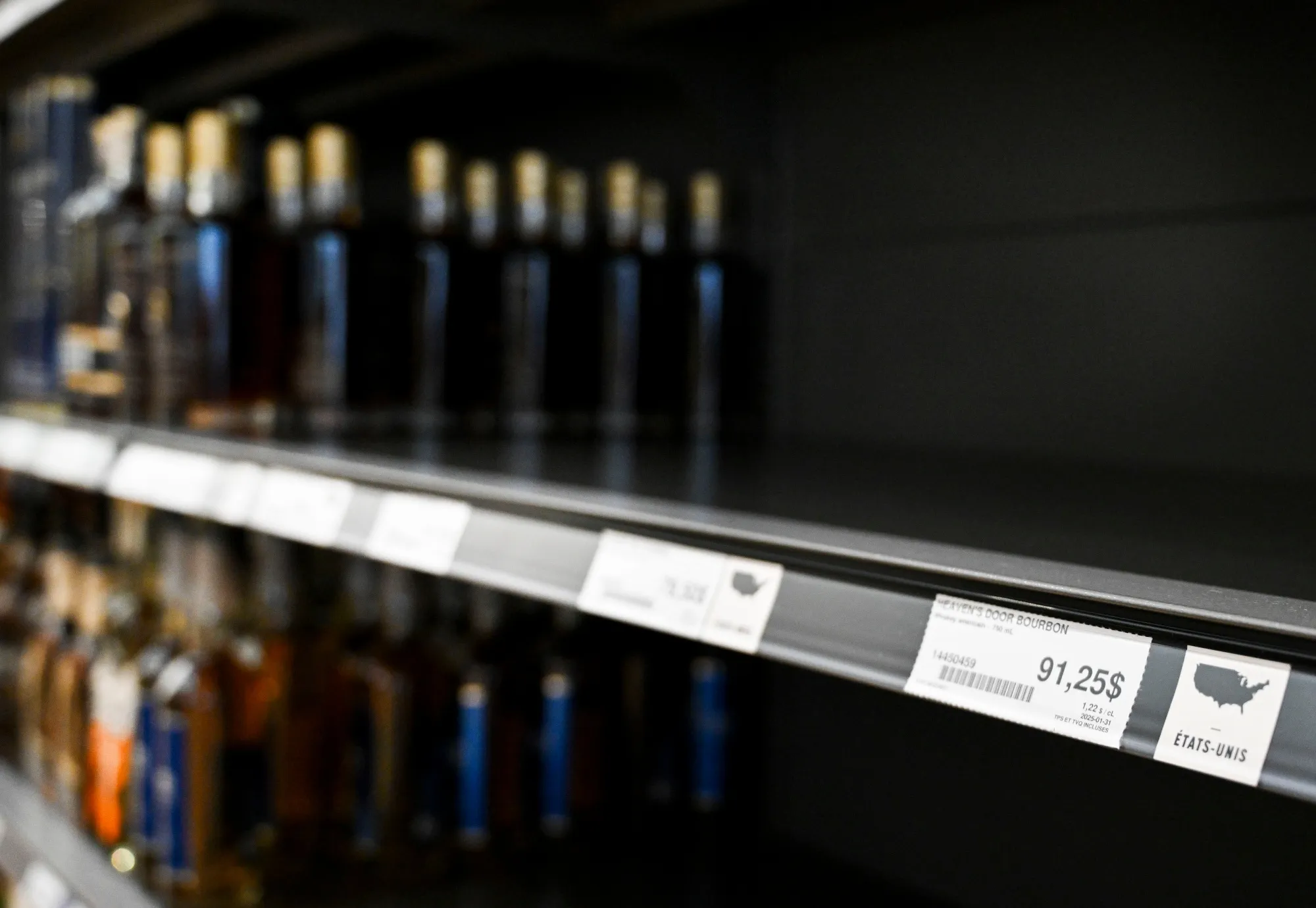 A price sticker for Heaven's Door bourbon near empty space on a shelf where American-made liquor had been at the Societe Des Alcools Du Quebec store.