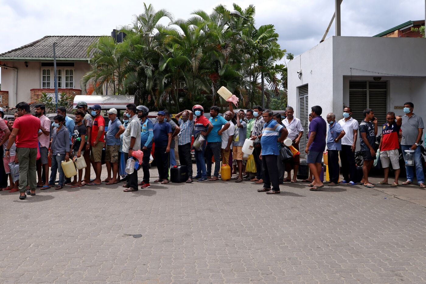 Customers queue with their containers to buy fuel at a gas station in Kandy, Sri Lanka, on Friday, June 17, 2022.&nbsp;