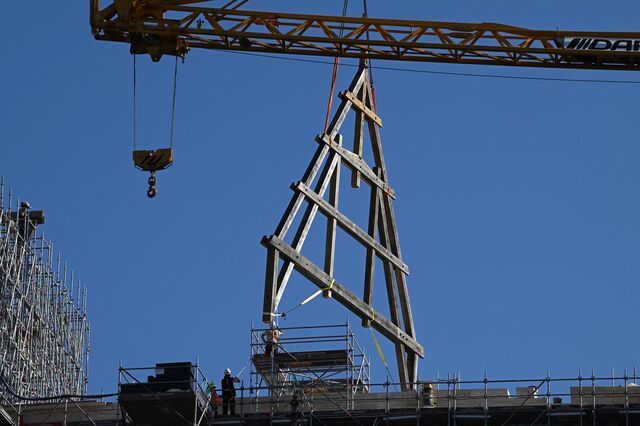 A truss is lifted into the air by a crane