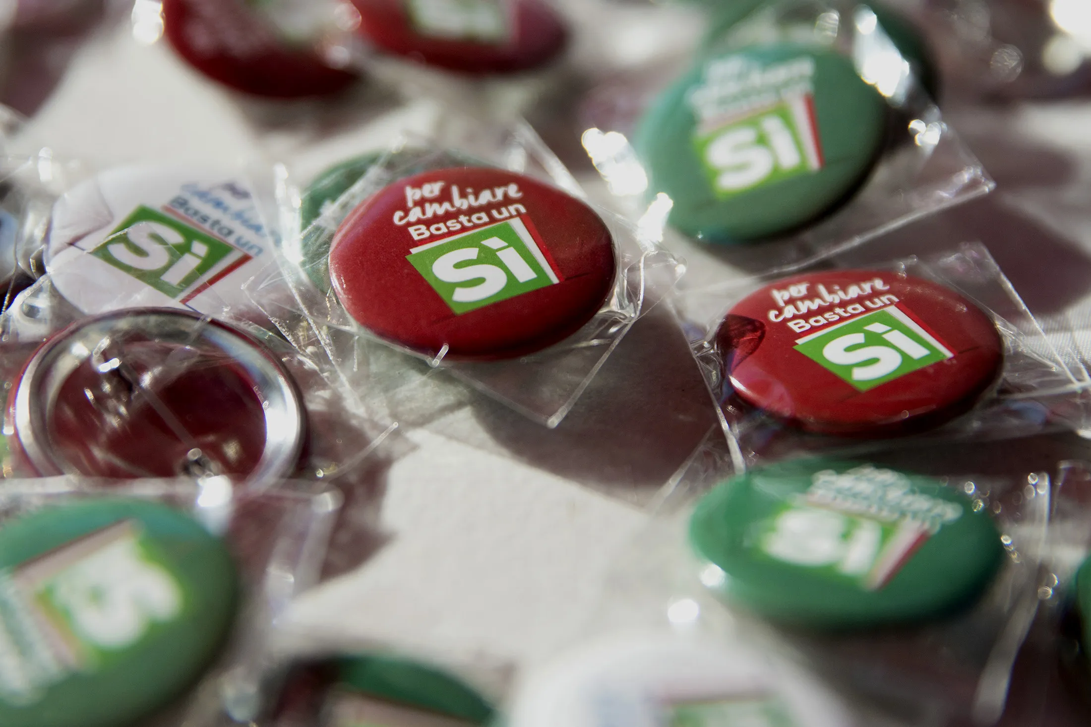 Pins reading 'To change, a Yes is enough' are displayed at a stall as Matteo Renzi, Italy's primer minister, not pictured, speaks during a Democratic Party and referendum campaign rally in Rome, Italy, on Saturday, Oct. 29, 2016. Renzi is betting that a Dec. 4 referendum on political reform will give him the backing needed to push through his economic agenda.
