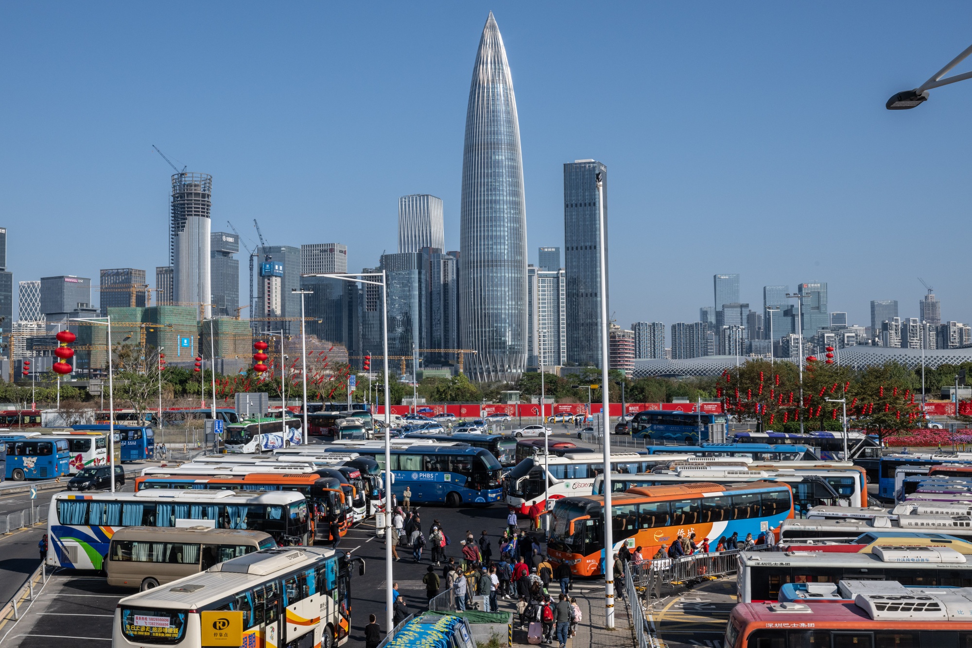 Tourists from Hong Kong board&nbsp;buses outside the Shenzhen Bay border crossing in Shenzhen.
