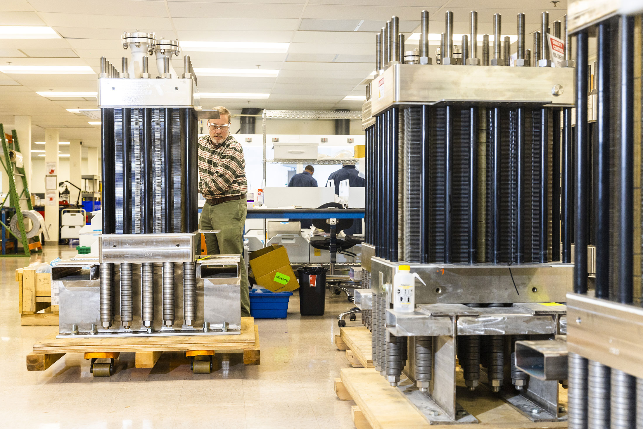 Staff members at Plug Power Electrolyzers move objects on the factory floor in Concord, Massachusetts, U.S., on Tuesday, July 5, 2022.