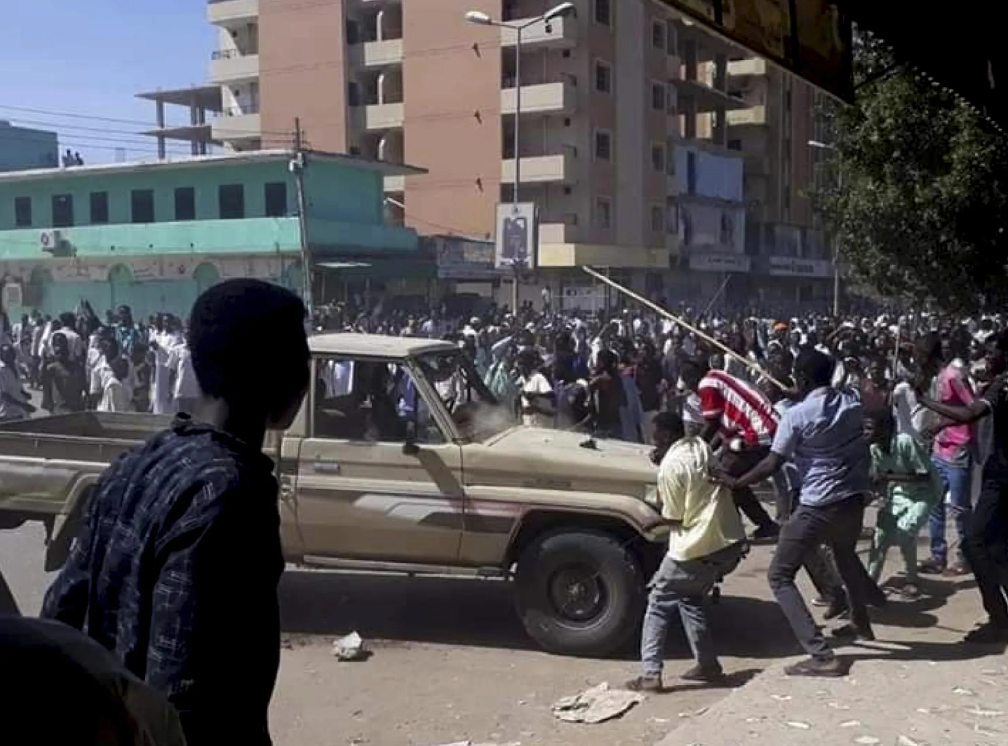 In this&nbsp;Dec. 23, 2018 handout photo provided by a Sudanese activist, people chant slogans and attack a national security vehicle during a protest in Kordofan, Sudan.
