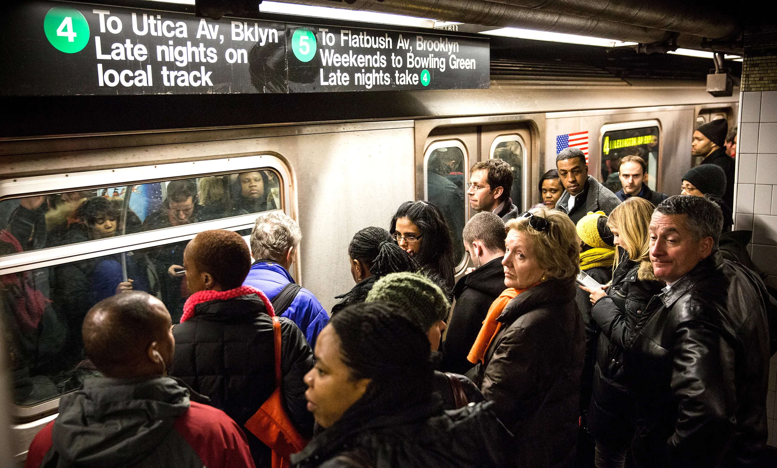 Commuters wait to board a New York City subway car at Grand Central Terminal during evening rush hour on March 10, 2014.
