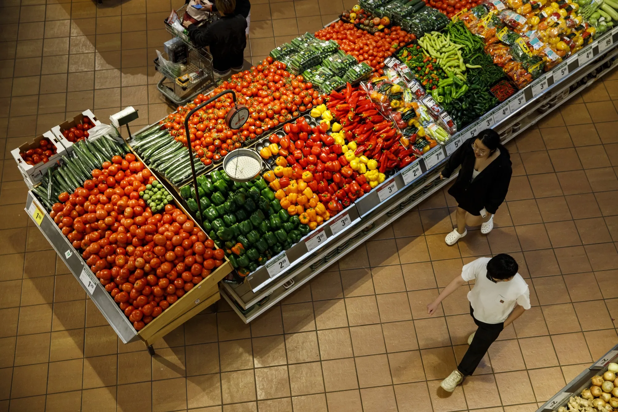 Shoppers walk through a produce aisle at a grocery store in Toronto.
