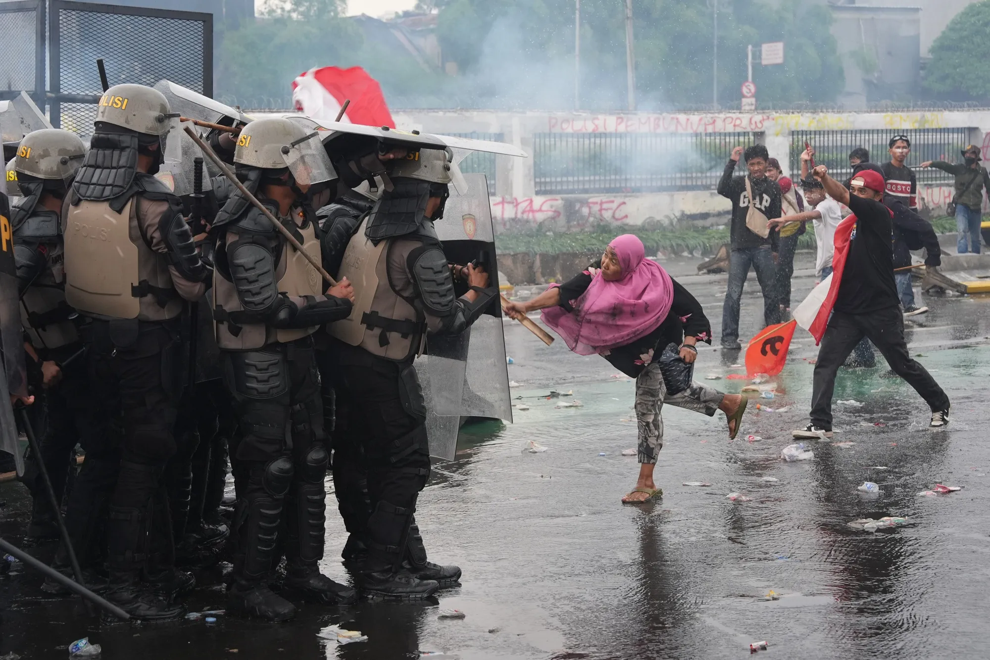 Demonstrators clash with riot police during a protest outside the parliament building in Jakarta.