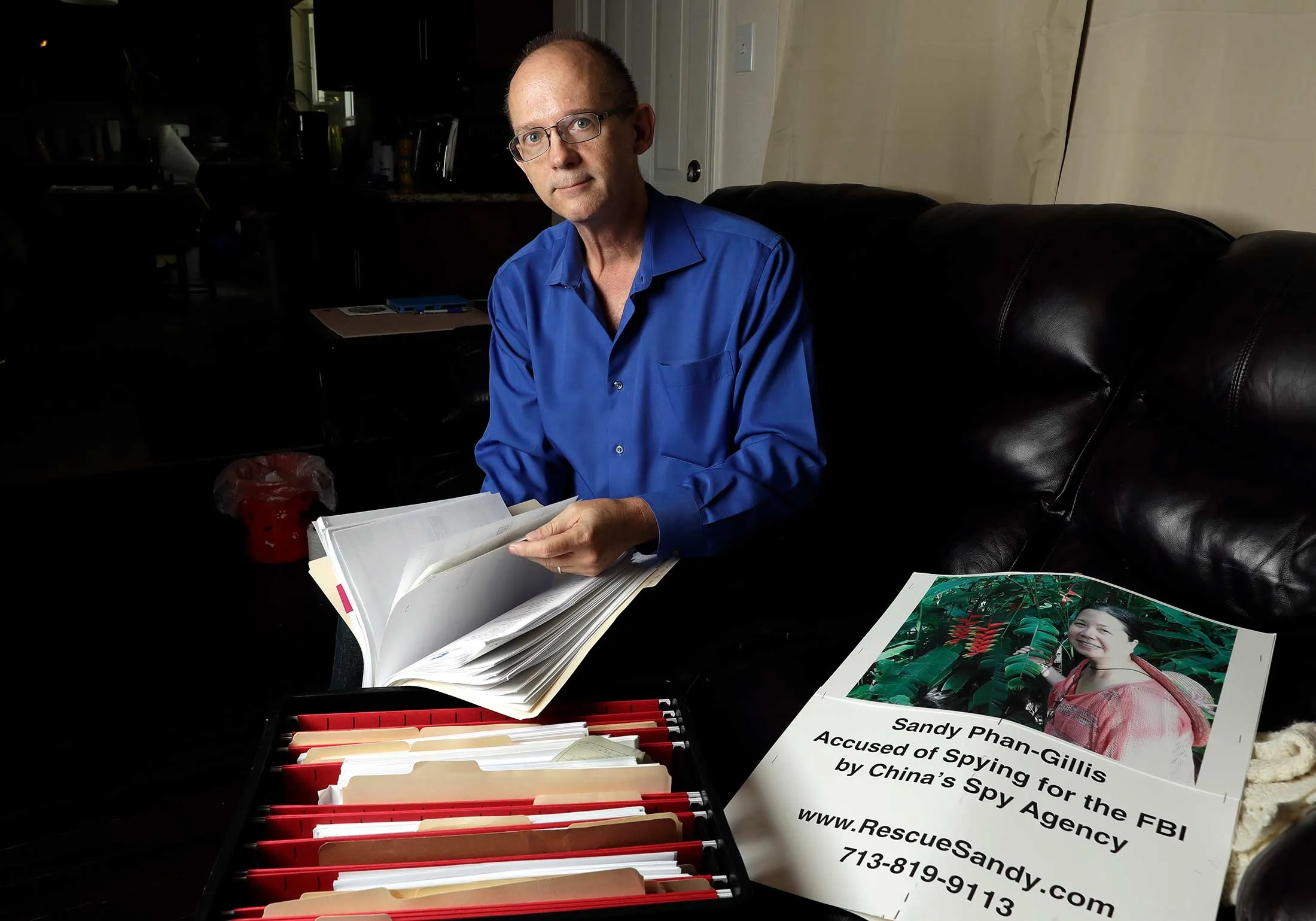 Jeff Gillis, the husband of U.S. citizen Phan “Sandy” Phan-Gillis, looks through documents he has collected in support of his wife in Houston, on Oct. 4, 2016.

