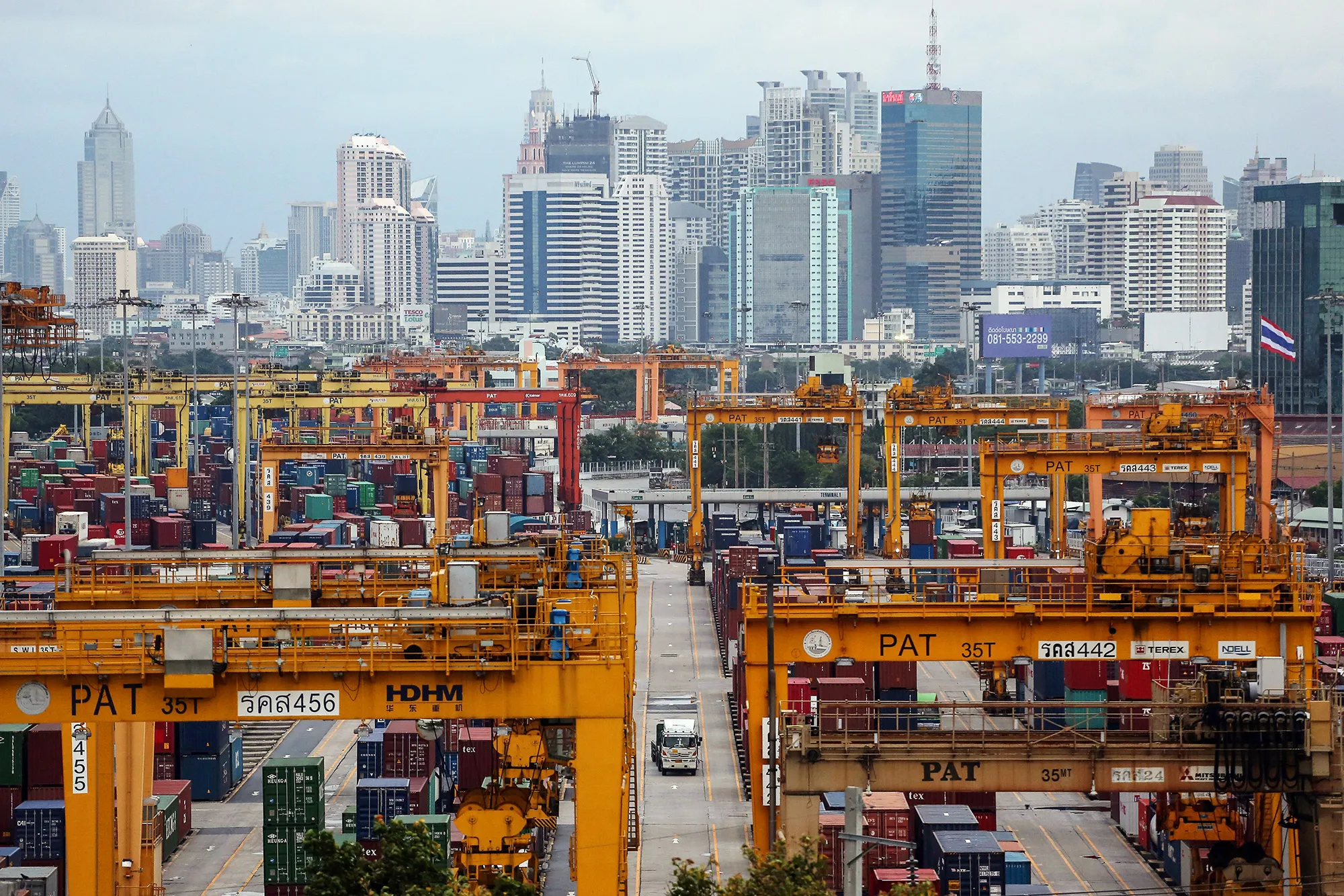 Containers sit stacked near gantry cranes at the Port of Bangkok.